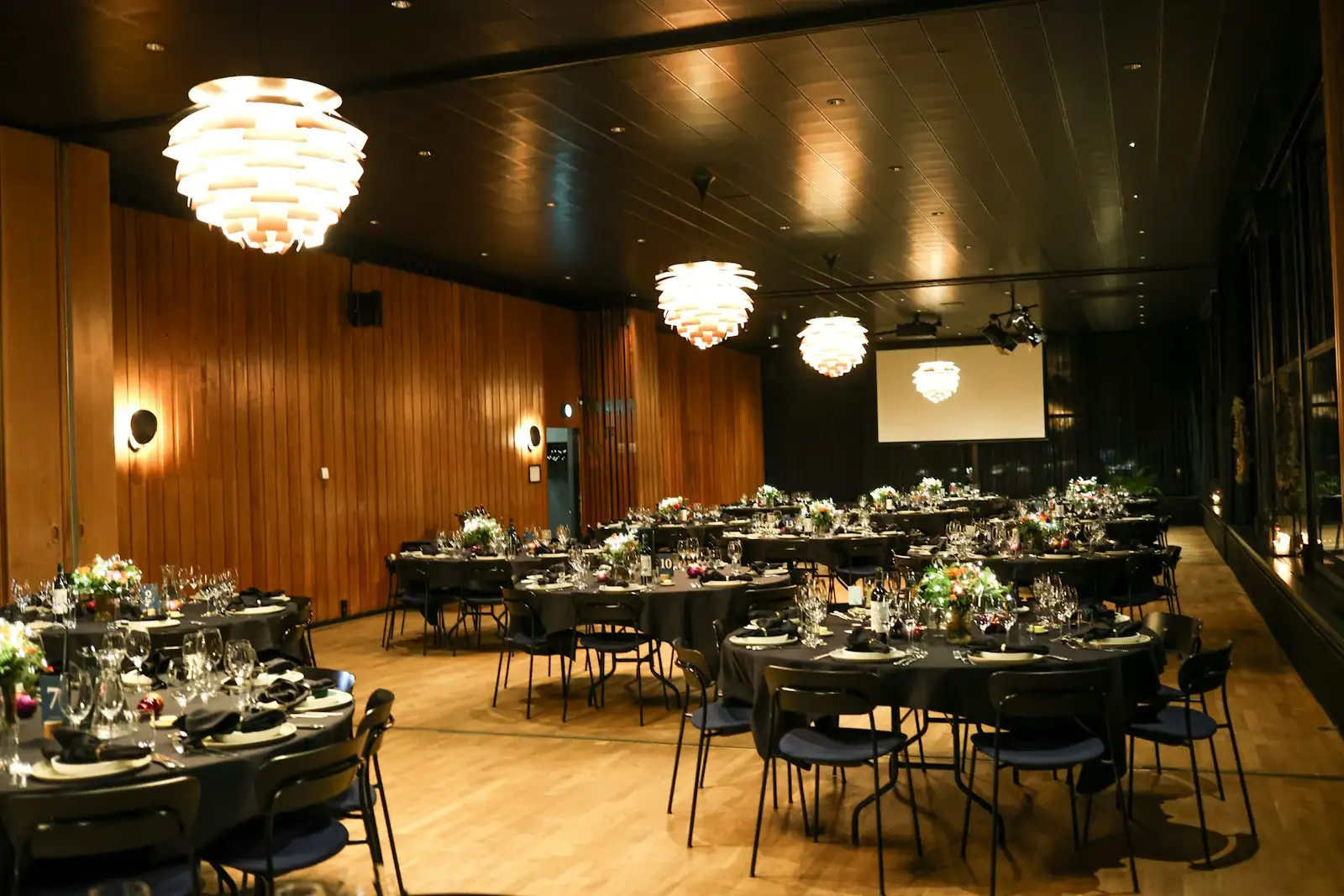 Festlich eingedeckter Saal mit runden Tischen
